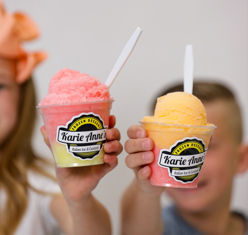 two children holding italian ice cups